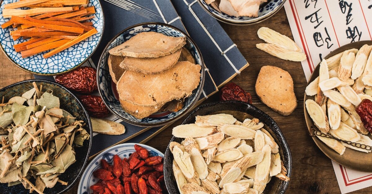 Ervas tradicionais da medicina chinesa em tigelas, destacando ingredientes naturais usados em tratamentos para equilíbrio e bem-estar.